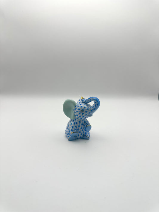 Small Baby Elephant Sitting Trunk Up Blue